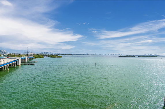 View of a large body of water with a bridge and city skyline in the distance.