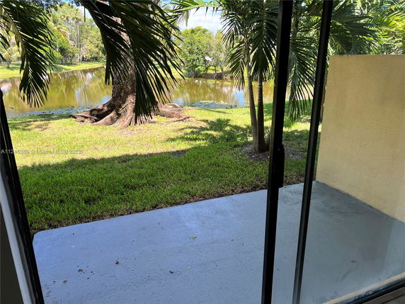 View of a lawn and pond seen from a building.