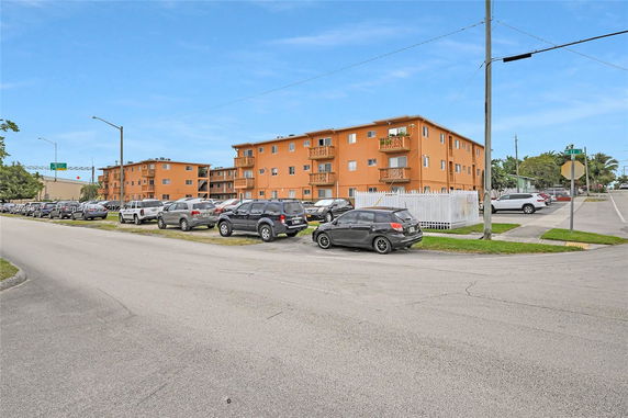 Outdoor parking area in front of a multi-story residential building