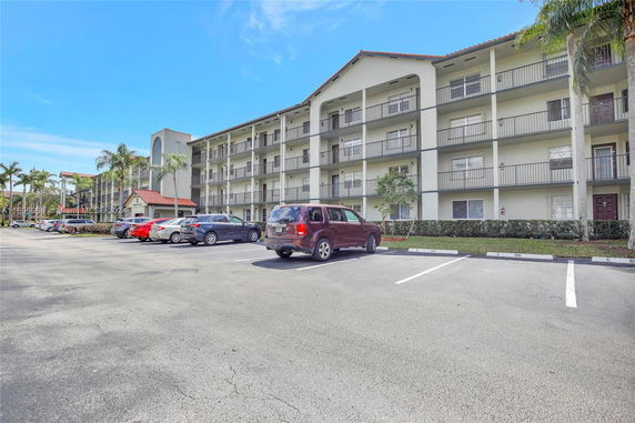 Outdoor parking area in front of a multi-story residential building.