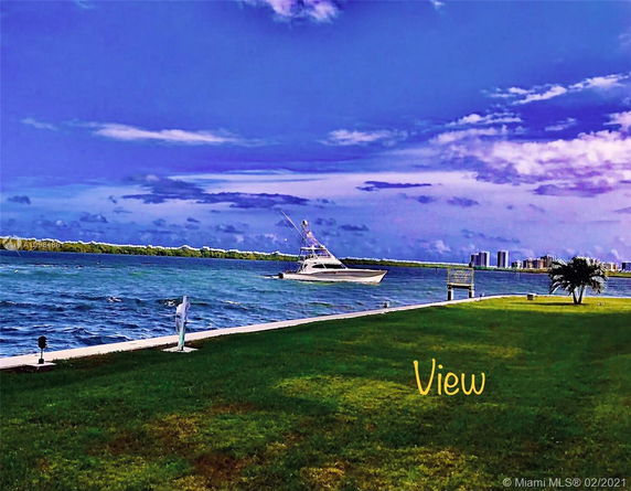 View of a body of water with a boat and distant buildings on the horizon.