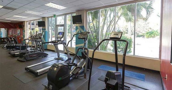 Indoor gym area with exercise equipment and large windows.