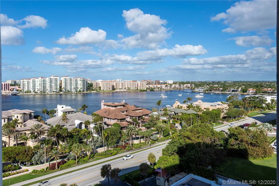 Aerial view of waterfront residential area with multi-story buildings across the water.