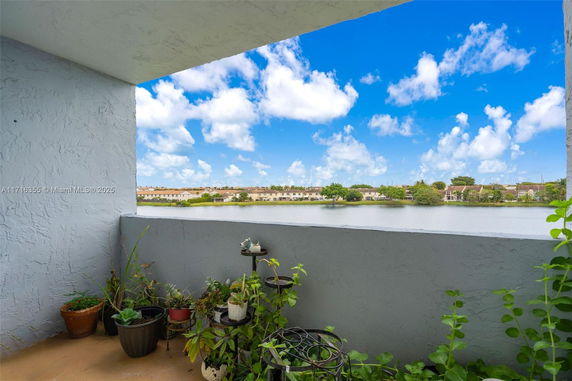 View from a building showcasing a lake and distant residential area.