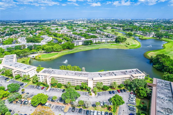 Aerial view of a large residential complex with multiple buildings surrounding a lake.