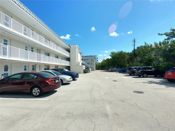 Outdoor parking area in front of a multi-level building.