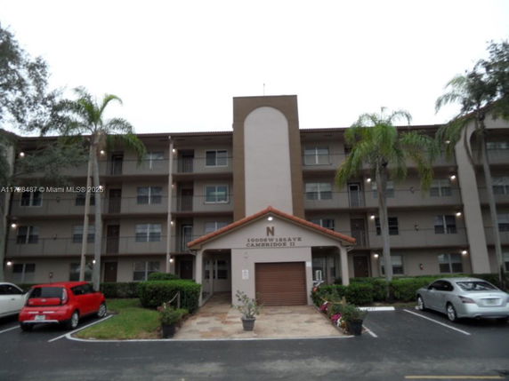 Front view of a multi-story apartment building with balconies and a central entrance.
