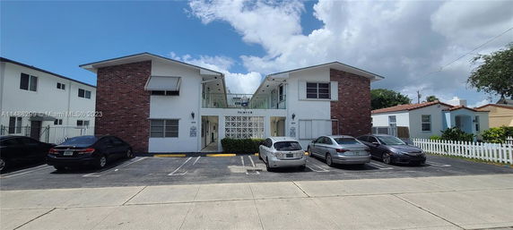 Front view of a two-story residential building with brick and white walls.