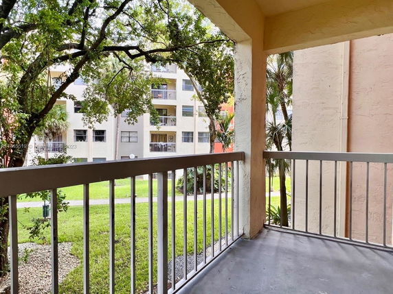 Balcony view overlooking surrounding buildings and greenery.