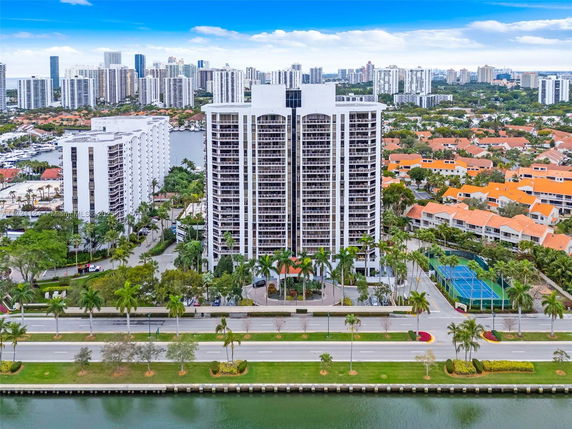 Aerial view of tall residential buildings surrounded by other buildings in a cityscape.