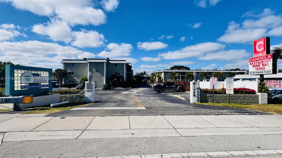 Entrance view of a residential complex with parking area.