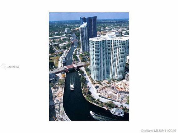 Aerial view of high-rise buildings near a river with surrounding cityscape.