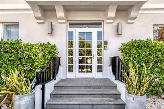 Front view of an entrance with glass double doors and steps leading up.