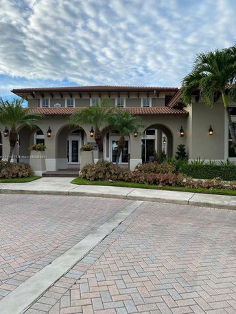 Front view of a two-story house with arched entrances and a tiled roof.