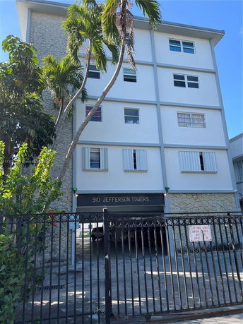 Front view of a multi-story building with a gated entrance.