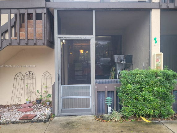 Front view of a building with a screened entrance and an external staircase.