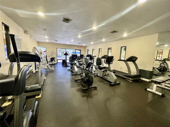 Indoor gym area with exercise equipment including treadmills and stationary bikes.