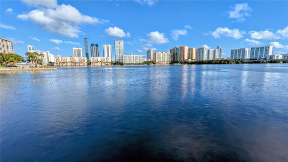 View of a city skyline with multiple high-rise buildings across a body of water.