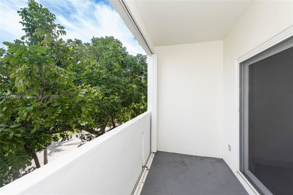 Balcony view showing trees and sky.