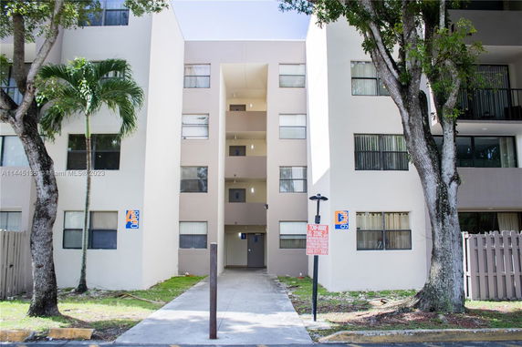 Front view of a multi-story apartment building with balconies.