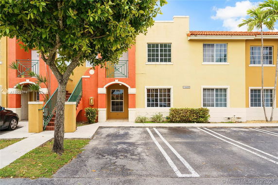Front view of a colorful two-story residential building with staircases.