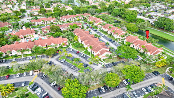 Aerial view of a residential area with multiple buildings having red roofs and surrounding parking lots.