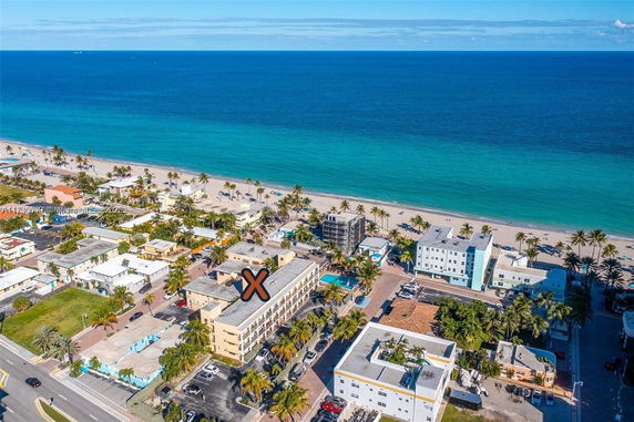 Panoramic view of coastal buildings near a beach, with the ocean in the background.