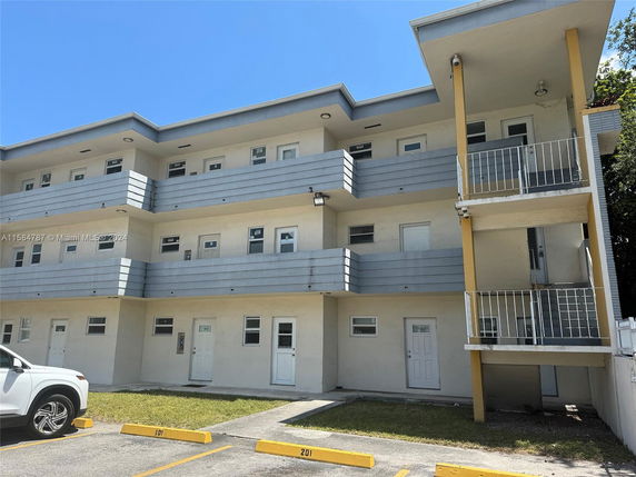 Front view of a three-story apartment building with balconies.