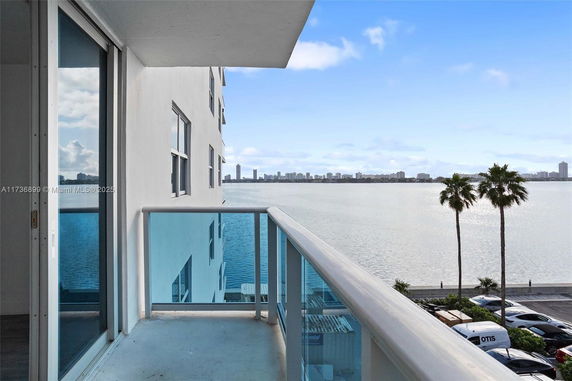 View from a balcony overlooking a body of water with distant city skyline.