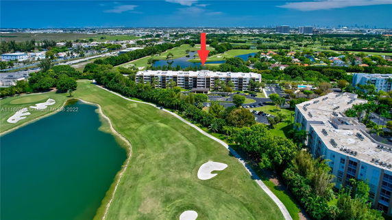 Panoramic view of an apartment complex surrounded by greenery and water features.