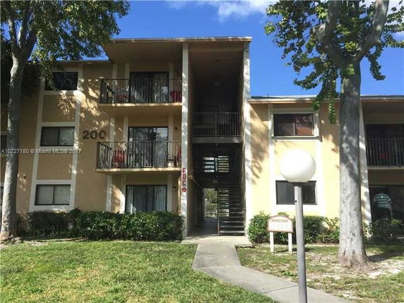 Front view of a three-story apartment building with balconies.