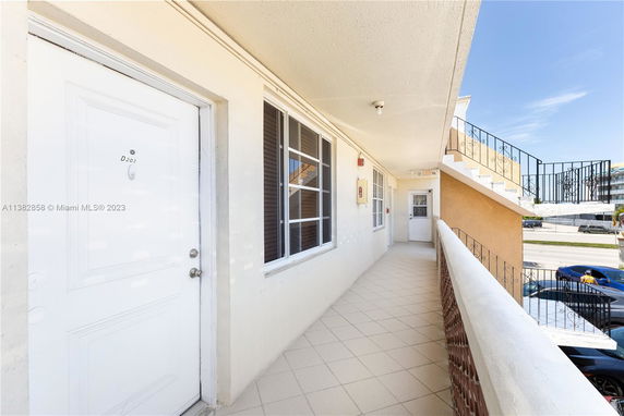Exterior view of a building with a walkway and stair access.