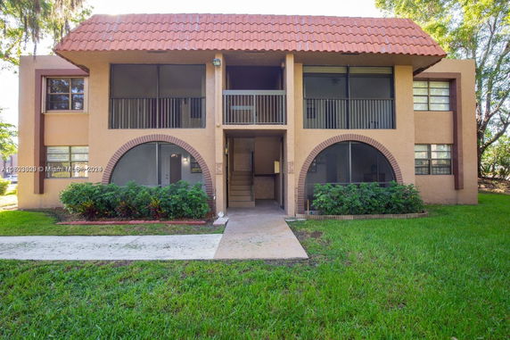 Front view of a two-story building with a tiled roof and an open entrance.