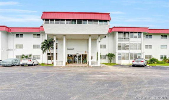 Front view of a multi-story building with red roof accents.