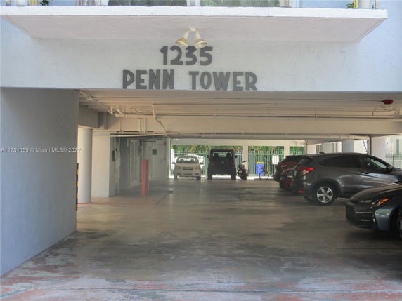 Covered parking area under a building named 1235 Penn Tower.