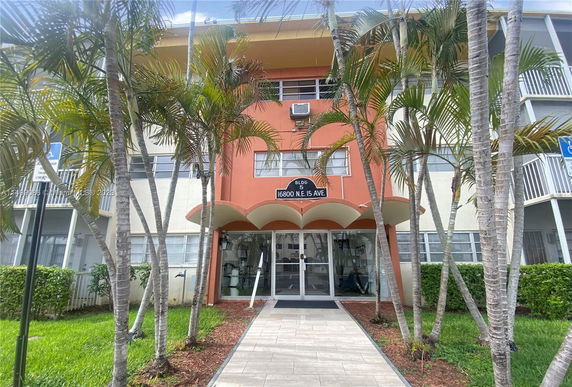 Front view of a multi-story building with glass entrance and decorative canopy.