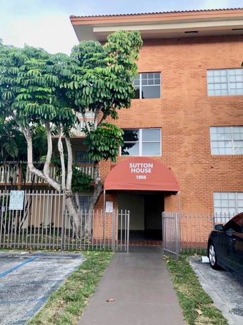 Front view of a multi-story building with brick exterior and a red canopy over the entrance.