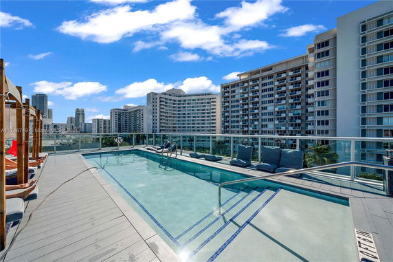 Rooftop swimming pool with surrounding high-rise buildings.