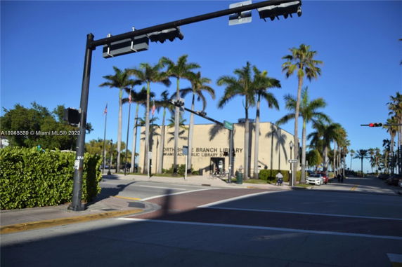 Front view of a library building with palm trees.