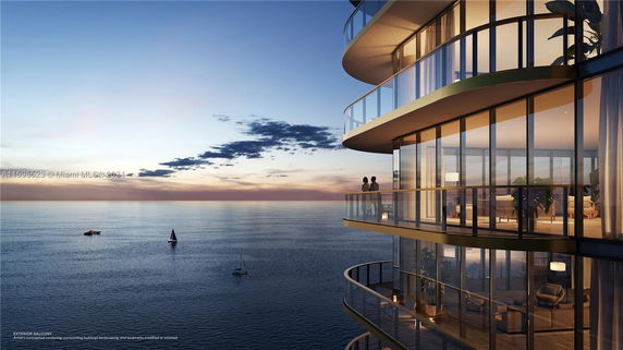 View of a modern building with curved glass balconies overlooking the ocean.