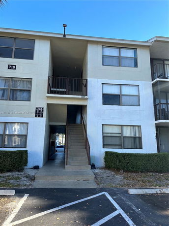 Front view of a multi-story apartment building with an exterior staircase.