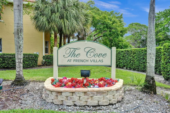 Signage for The Cove at French Villas surrounded by trees and landscaping.