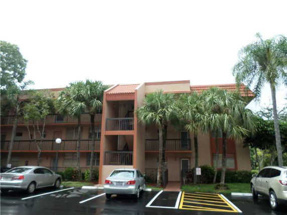 Front view of a multi-story apartment building with balconies.
