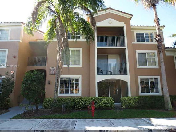 Front view of a multi-story residential building with balconies and multiple windows.