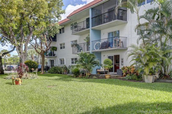 Front view of a multi-story residential building with balconies and landscaping.