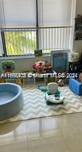 Indoor children's play area with toys and a small pool on a mat.