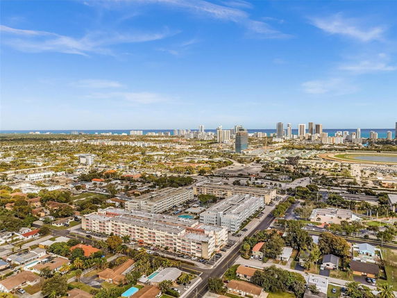 A panoramic view of a cityscape with mid-rise and high-rise buildings near the coastline and expansive surroundings.