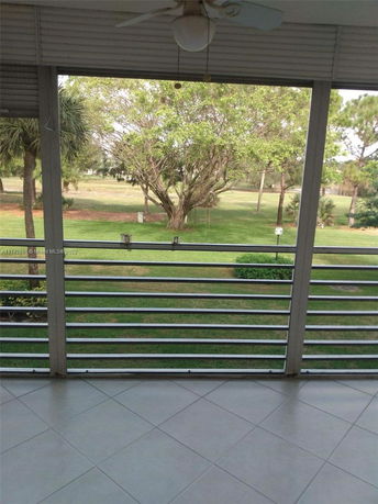 View from a balcony showing a grassy area with trees.
