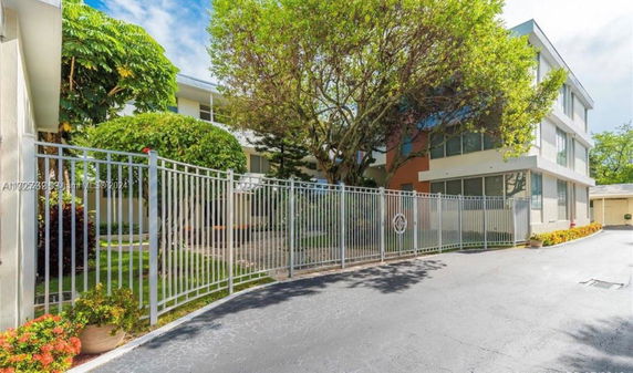 Front view of a multi-story building with a metal fence.