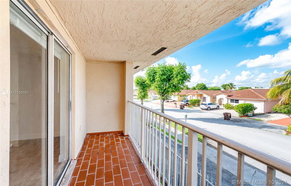 Balcony view overlooking a residential street with houses.